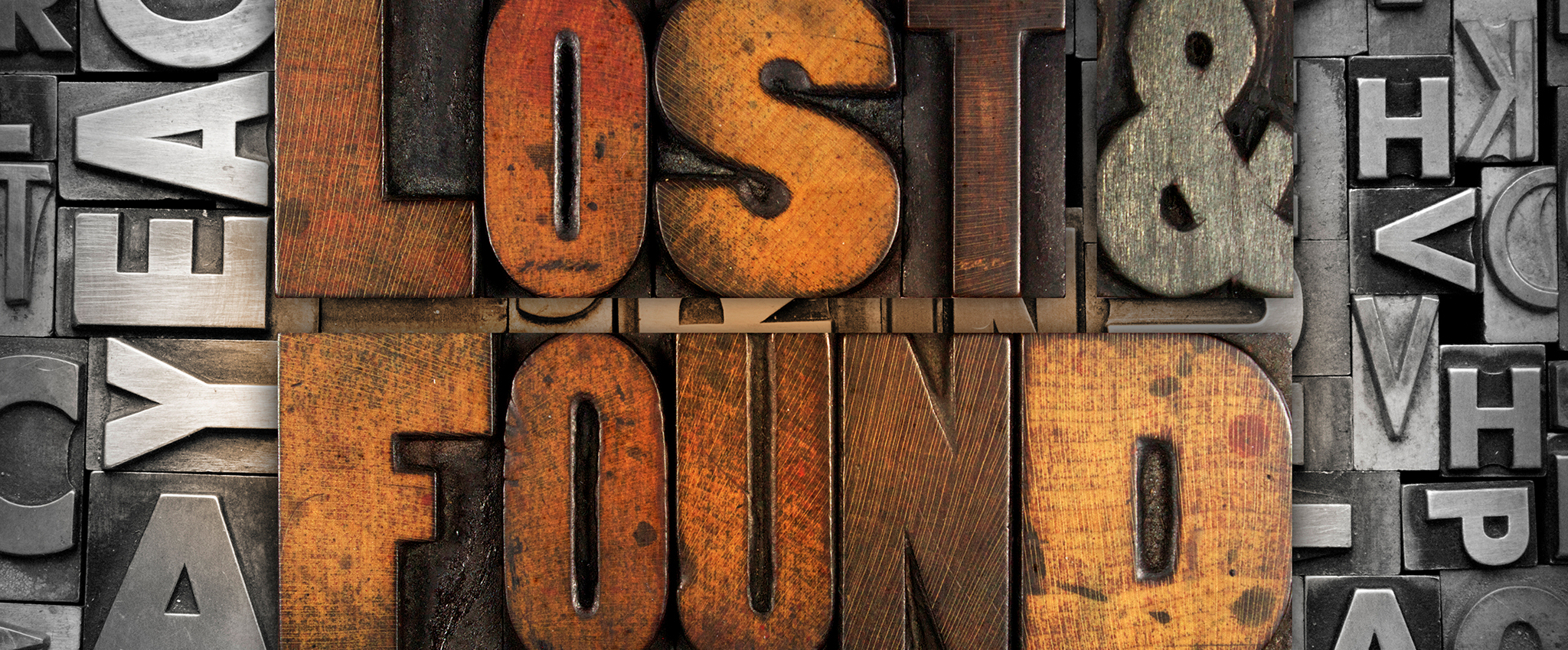 Large wooden movable-type letters that, together, spell out "Lost & Found" sit amongst a variety of metal movable-type letters.