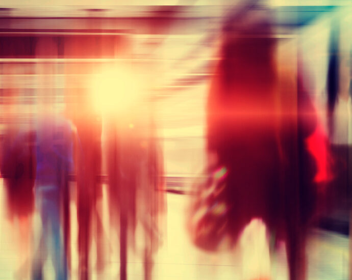 A blurred and stylized image of business people walking through a city subway at rush hour.