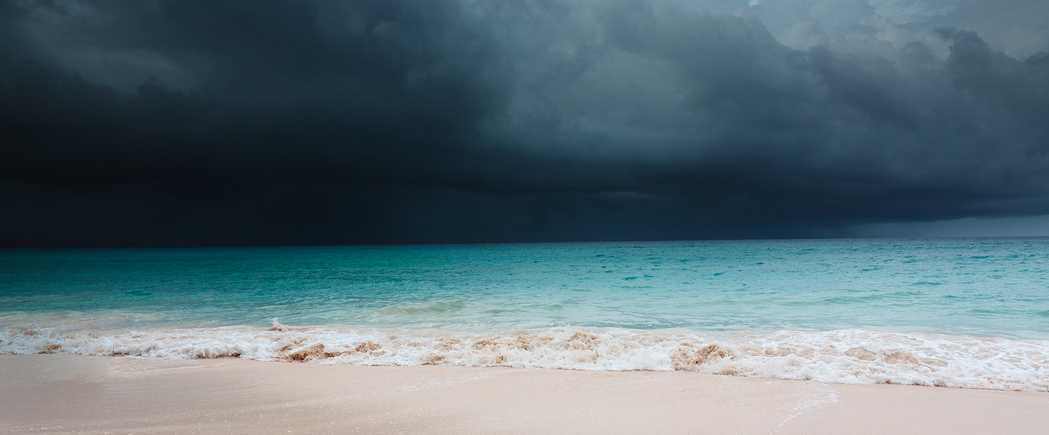 A tropical storm is coming across the crystaline-blue ocean in Barbados.
