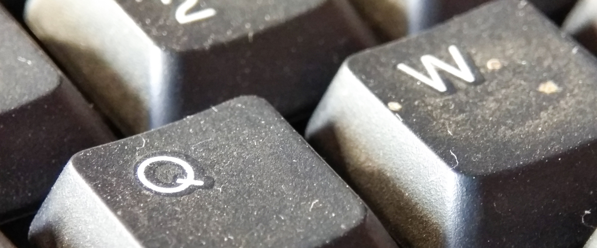 A close-up of a dust-covered, dirty computer keyboard.
