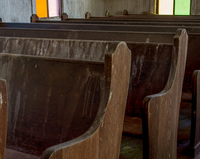 Worn wooden pews and colorful windows line the center aisle of a little old church. Taken at First Methodist Church of Jermyn. NOTE: this church was built in 1910. In 1968, it was designated as a Texas Historic Landmark.