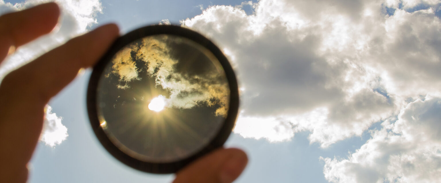 Looking at the sun through a neutral lens filter for a camera.