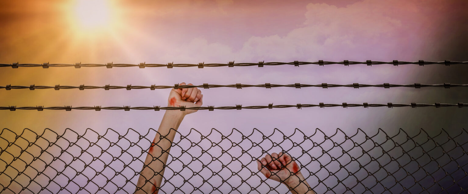 Teen girl behind barbed wired fence (Image: Wavebreakmedia Ltd.)
