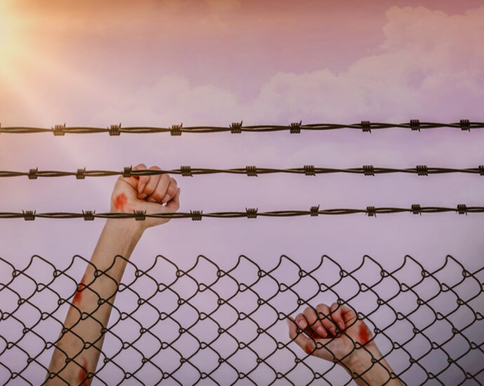 Teen girl behind barbed wired fence (Image: Wavebreakmedia Ltd.)