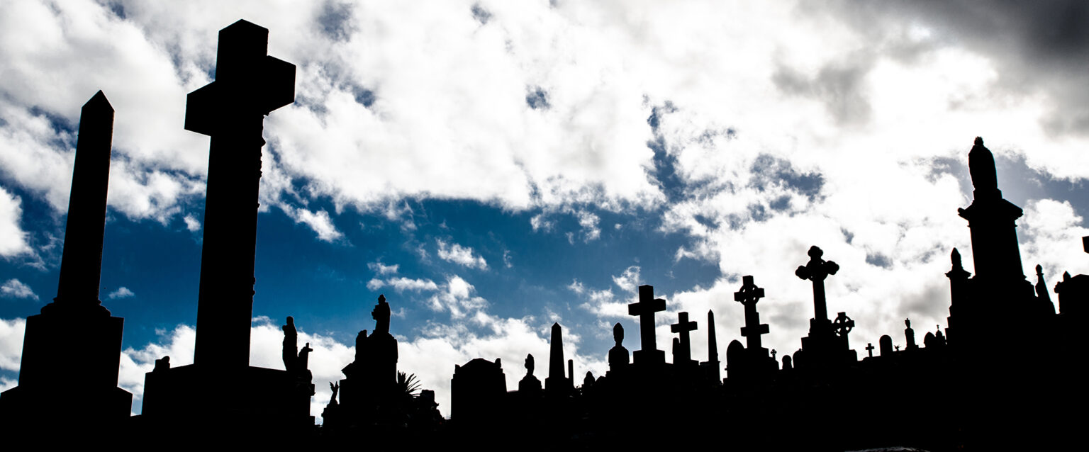 A Silhouette of graveyard, the image shows many cross tombstone with dramatic cloudy sky.
