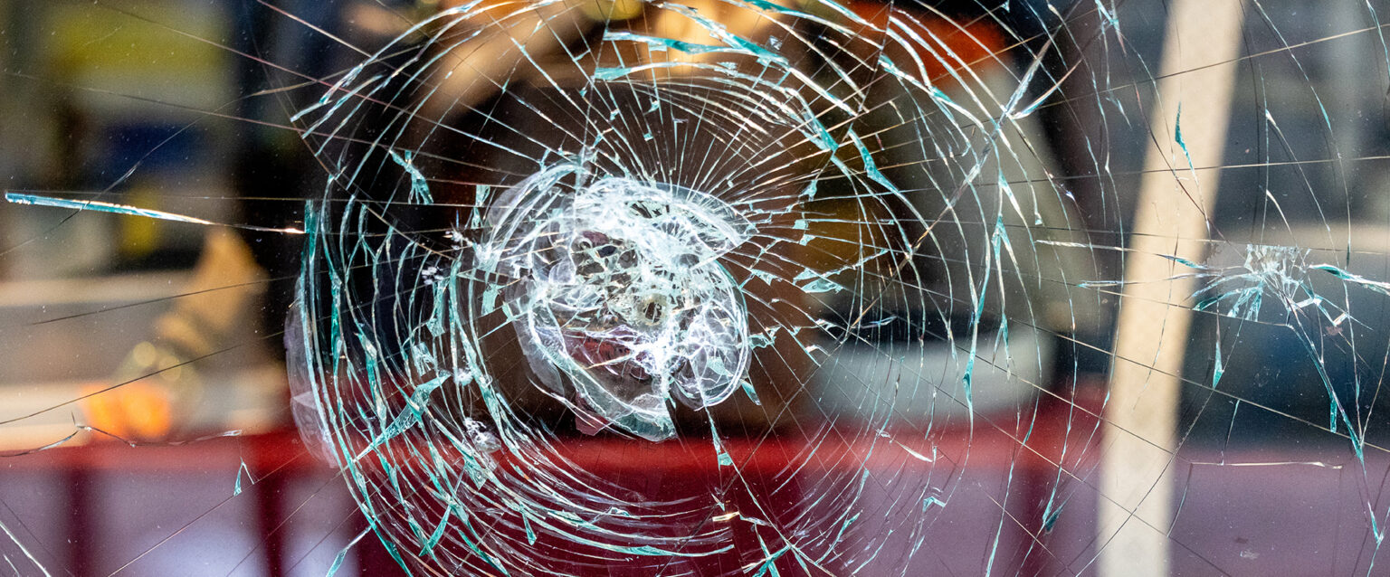 A shattered shop window shows signs of an attempted burglary.
