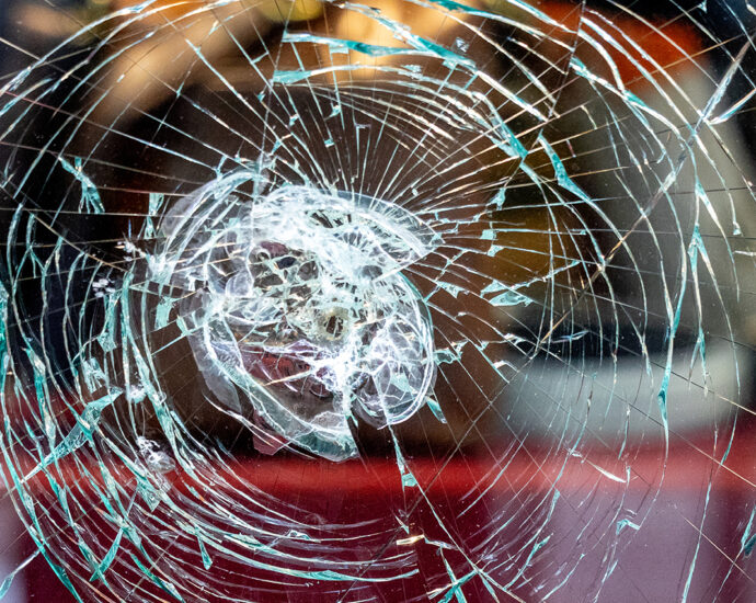 A shattered shop window shows signs of an attempted burglary.