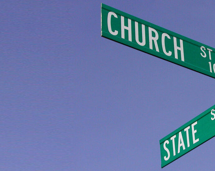 Street signs backed by a clear blue sky, at the intersection of Church and State Streets in Salem, Oregon.