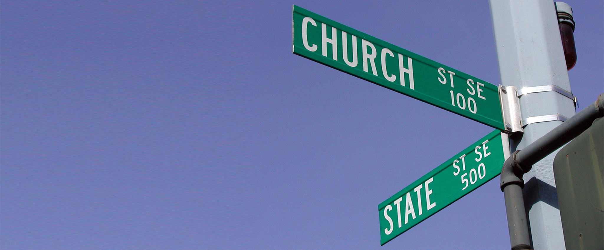 Street signs backed by a clear blue sky, at the intersection of Church and State Streets in Salem, Oregon.