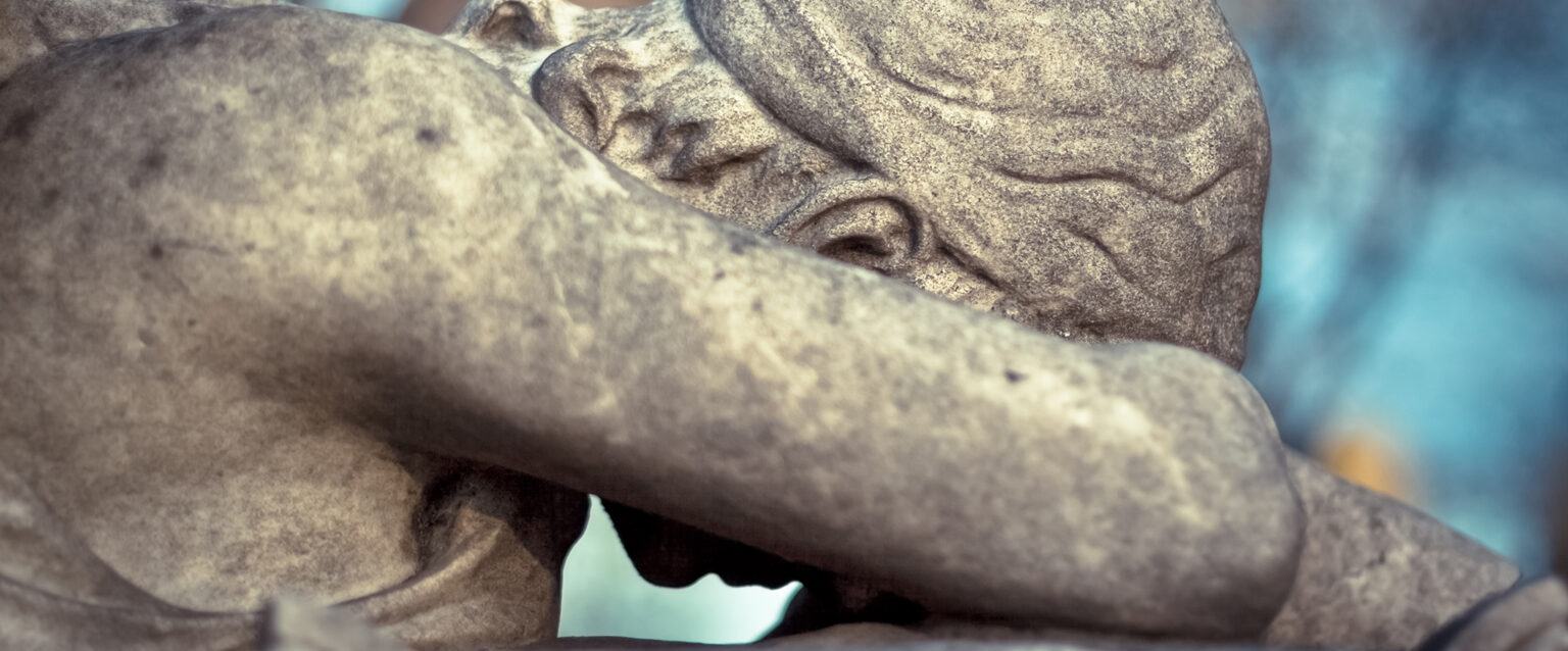 Angel of Grief Statue. A beautifully carved statue of an angel with her head down, forehead on her crossed arm, weeping in utter grief.