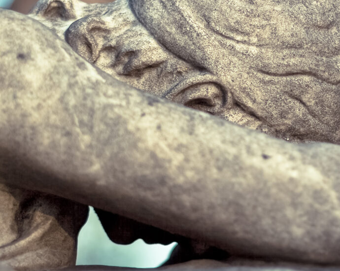 Angel of Grief Statue. A beautifully carved statue of an angel with her head down, forehead on her crossed arm, weeping in utter grief.